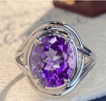 Elegant amethyst fashion ring for women with a silver band, featuring a large purple gemstone center.