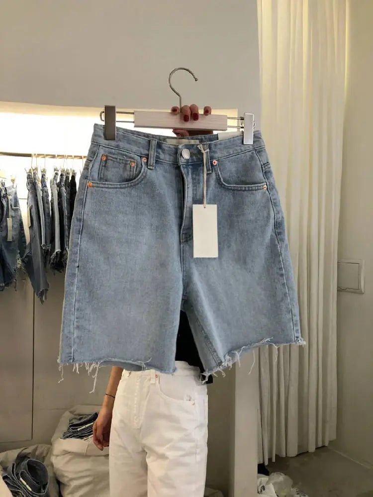 Light blue loose casual women's five-point denim shorts with frayed edges and five-pocket design on a white background.