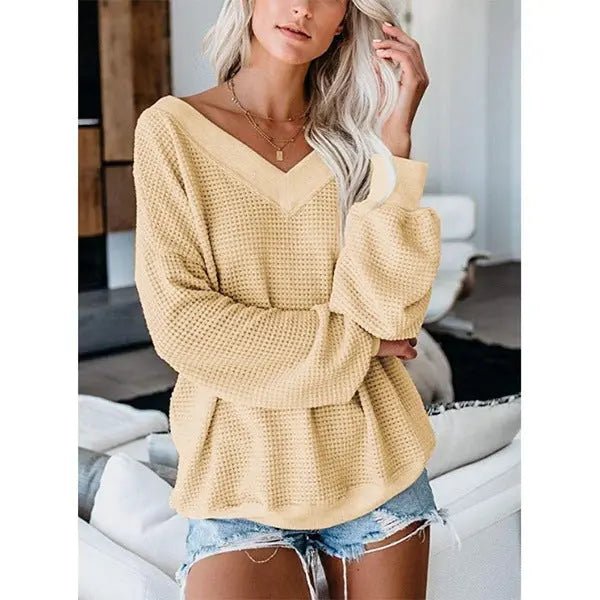 Loose V-neck knit sweater with plaid pattern, featuring a relaxed fit and cozy fabric, ideal for casual fall or winter wear.