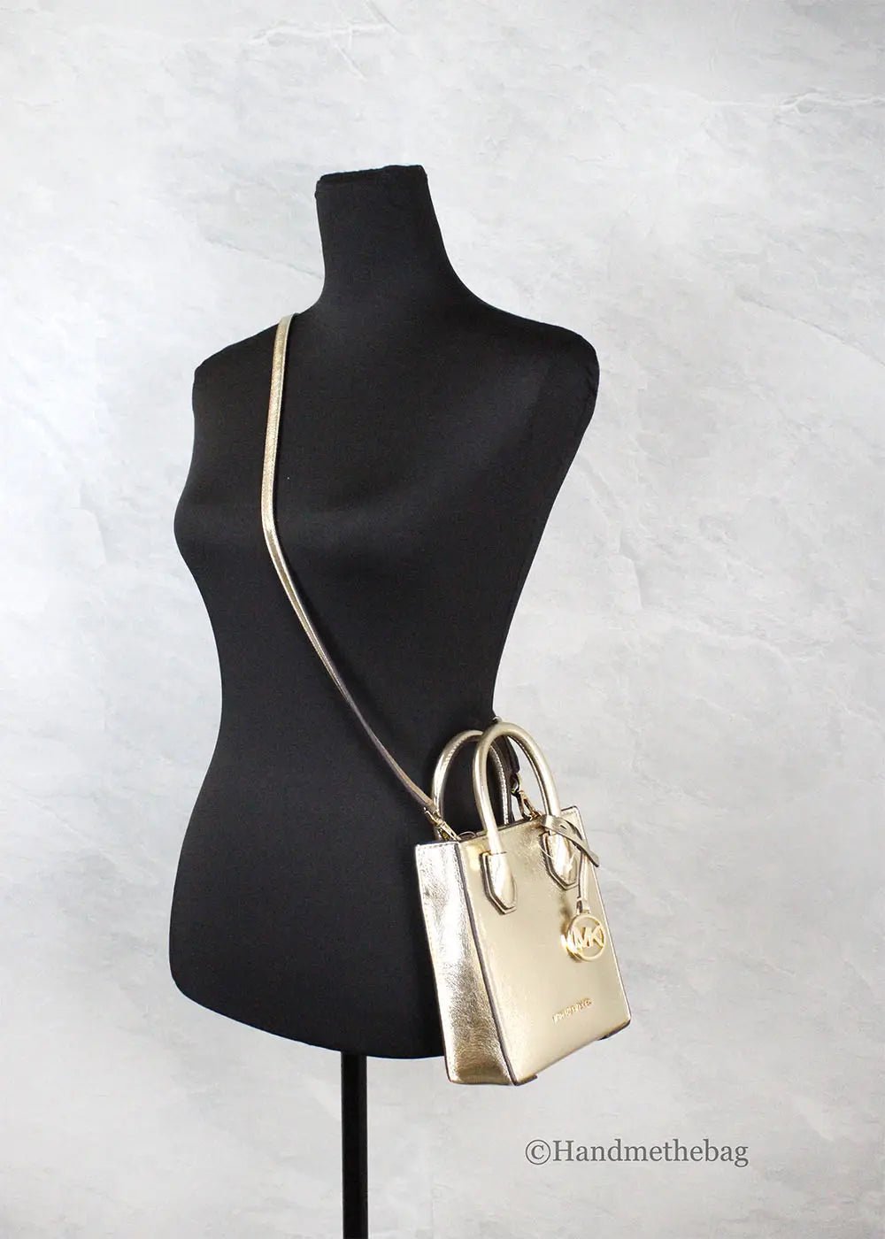 Michael Kors Mercer XS pale gold crossbody bag with gold hardware and sleek design, perfect for stylish everyday use.