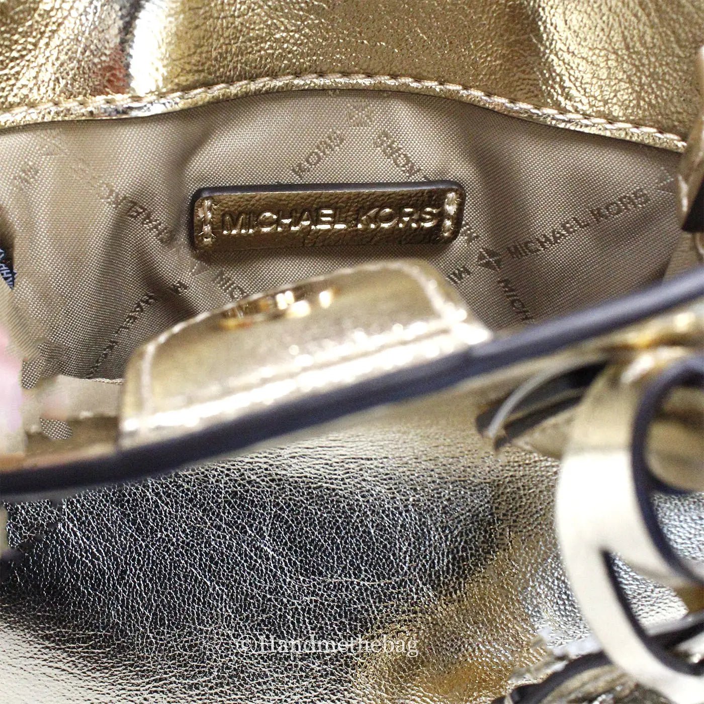 Michael Kors Mercer XS Pale Gold North South Crossbody Bag with gold hardware and adjustable strap.
